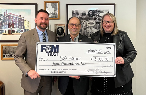 OFAC Visual Credit Union representatives present a large check to Safe Harbour